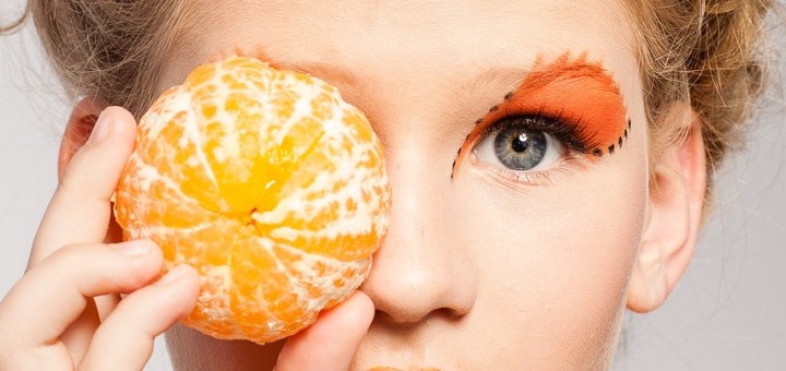 woman with an orange to her eye