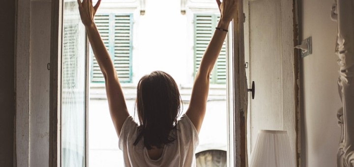 Woman opening a widnow in the morning