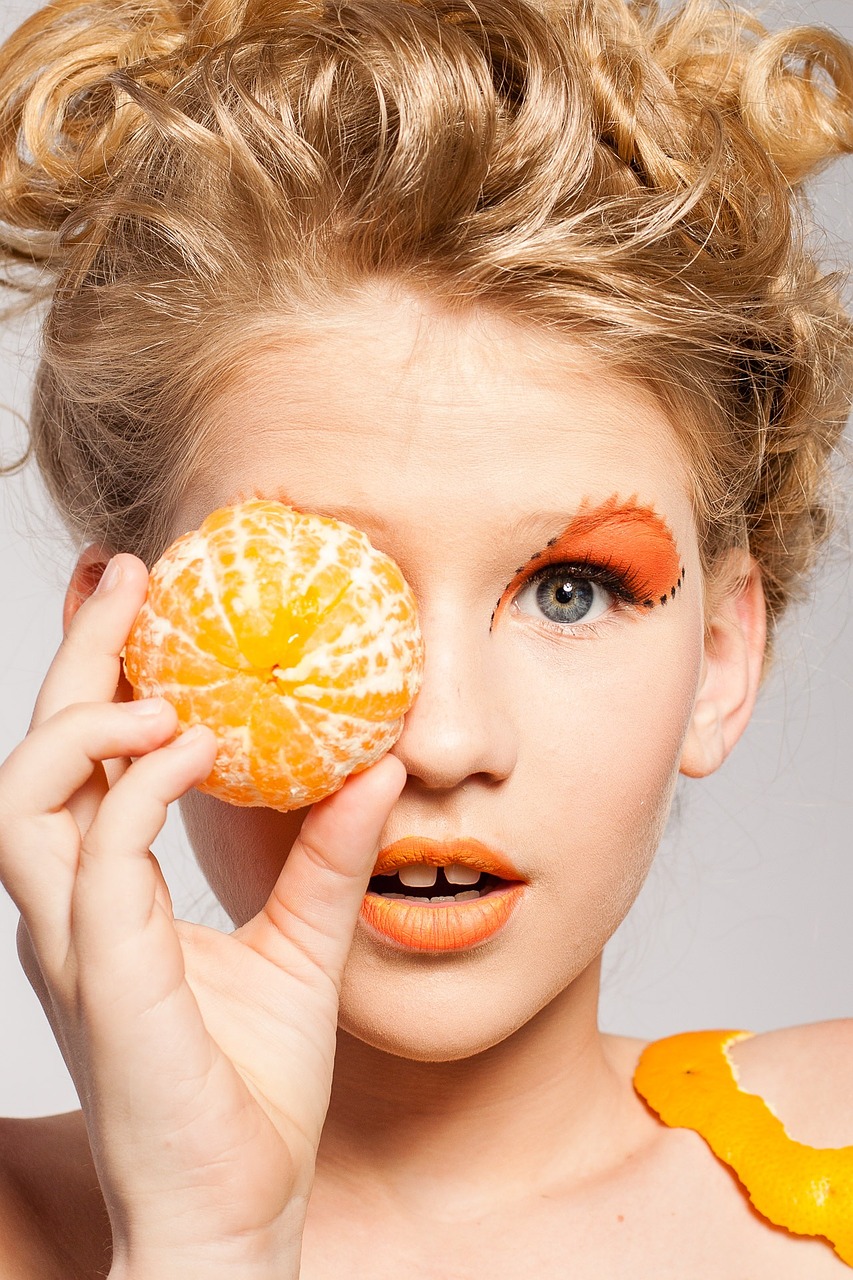 woman with an orange to her eye