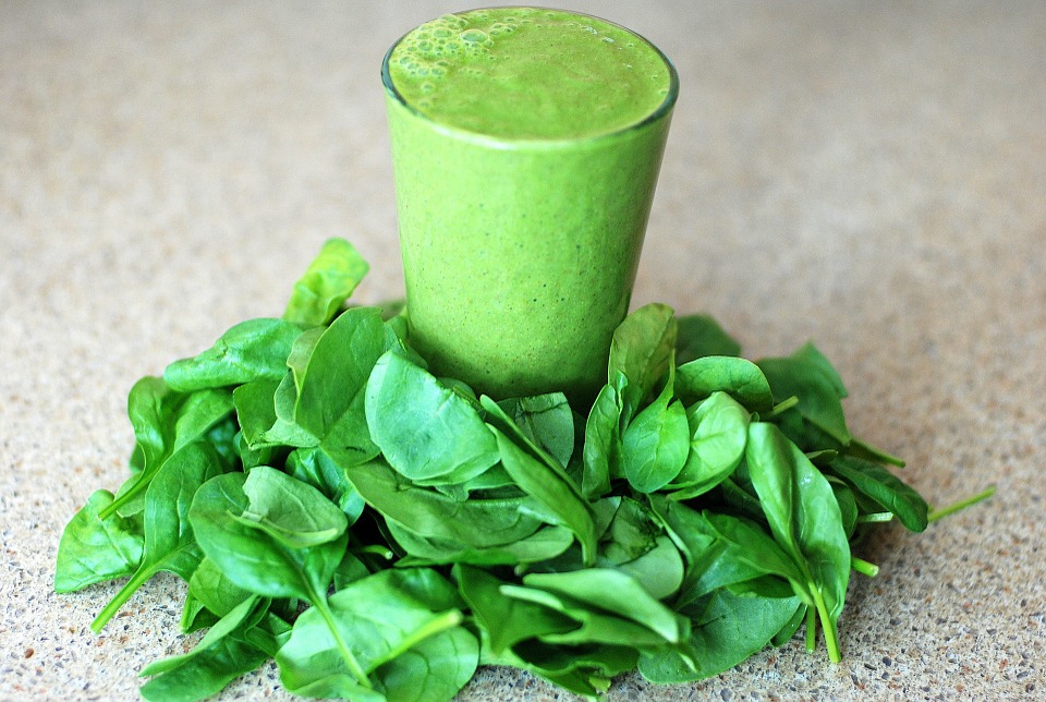 Green smoothie surrounded by leaves